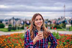 Beautiful young woman holding coffee cup and smiling