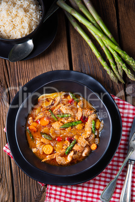 Turkey fricassee on rice with asparagus and paprika