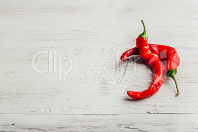 Red chili peppers on wooden background.