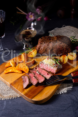 rustic medium butter beef steak with herbs and potato wedges
