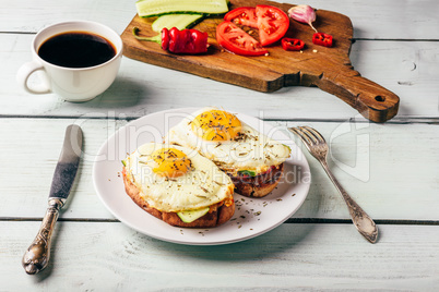 Toasts with vegetables and fried egg and cup of coffee