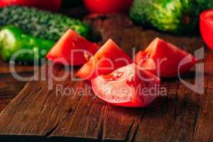 Sliced tomatoes on cutting board and cucumbers with chili pepper