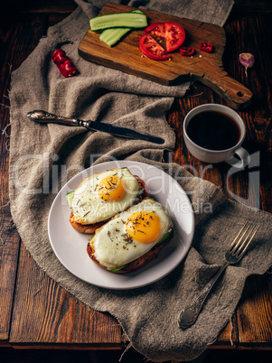 Breakfast toasts with vegetables and fried eggs with cup of coff
