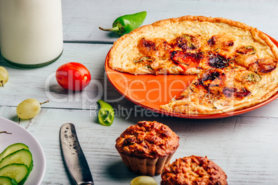 Frittata with muffins over light wooden background.