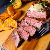 rustic medium butter beef steak with herbs and potato wedges