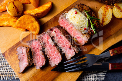 rustic medium butter beef steak with herbs and potato wedges