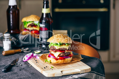 Burger on Cutting Board with  Bottle of Beer.