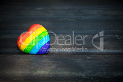 Decorative Heart with rainbow stripes on dark wooden background. LGBT pride flag, symbol of lesbian, gay, bisexual, transgender for social movements. Homosexual love, Human rights concept. Copy space.