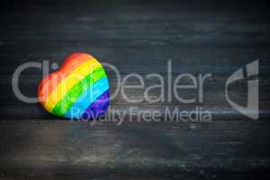 Decorative Heart with rainbow stripes on dark wooden background. LGBT pride flag, symbol of lesbian, gay, bisexual, transgender for social movements. Homosexual love, Human rights concept. Copy space.