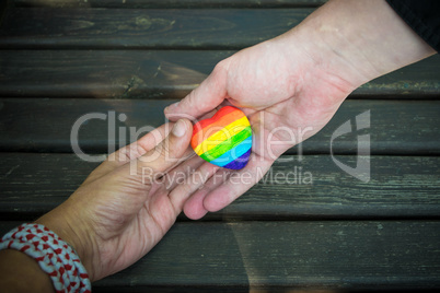 Decorative Heart with rainbow stripes in male hands. LGBT pride flag, symbol of lesbian, gay, bisexual, transgender for social movements. Homosexual love, Human rights concept. Copy space.