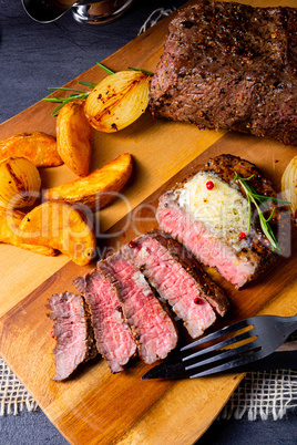 rustic medium butter beef steak with herbs and potato wedges