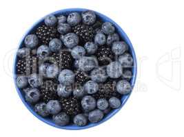 Bowl full of fresh blackberries and blueberries on white backgro