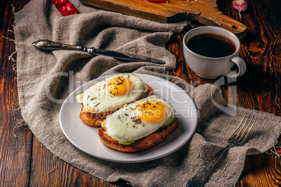 Bruschettas with vegetables and fried eggs with cup of coffee
