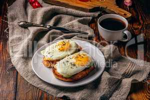 Bruschettas with vegetables and fried eggs with cup of coffee