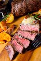 rustic medium butter beef steak with herbs and potato wedges