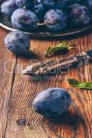 Ripe plums with leaves and knife