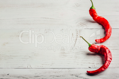 Chili peppers over light background.
