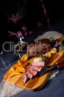 rustic medium butter beef steak with herbs and potato wedges