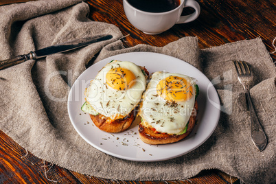 Italian toasts with vegetables and fried eggs on white plate and