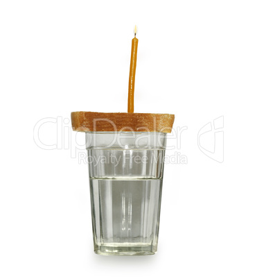 Glass of water and bread and candle