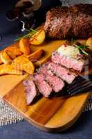 rustic medium butter beef steak with herbs and potato wedges