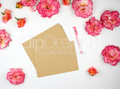 pink rose buds and a brown paper envelope