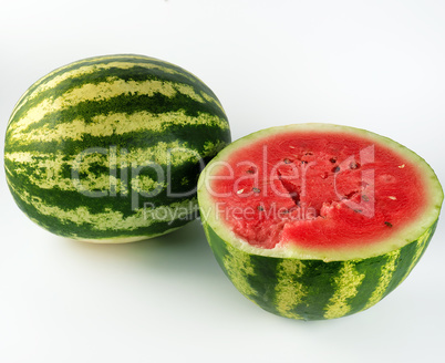 half ripe watermelon with red juicy pulp and seeds and a whole g