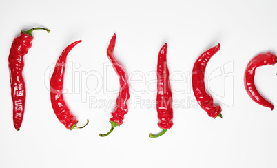 whole ripe red hot chili peppers on a white background