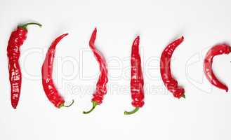 whole ripe red hot chili peppers on a white background