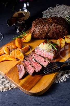 rustic medium butter beef steak with herbs and potato wedges