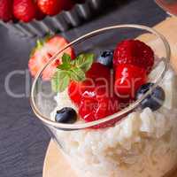 delicious milk rice with different berries and red fruit jelly