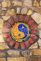 Mosaic symbol of Yin and yang on stone wall.