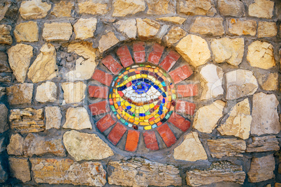 Mosaic Eye of Horus on stone wall.