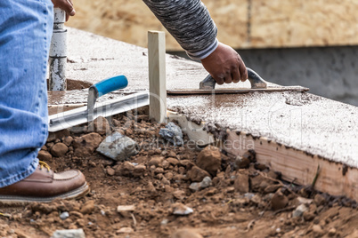 Construction Worker Using Wood Trowel On Wet Cement Forming Copi