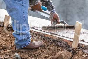 Construction Worker Using Wood Trowel On Wet Cement Forming Copi