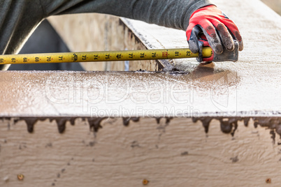 Cement Construction Worker Using Measuring Tape While Forming Po