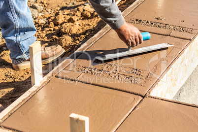 Construction Worker Using Trowel On Wet Cement Forming Coping Ar