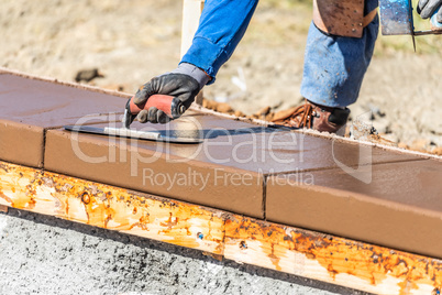 Construction Worker Using Trowel On Wet Cement Forming Coping Ar