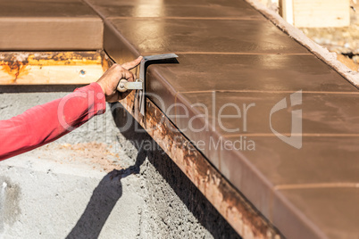 Construction Worker Using Stainless Steel Edger On Wet Cement Fo