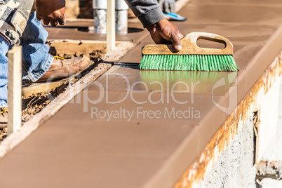 Construction Worker Using Brush On Wet Cement Forming Coping Aro
