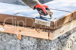 Construction Worker Using Stainless Steel Edger On Wet Cement