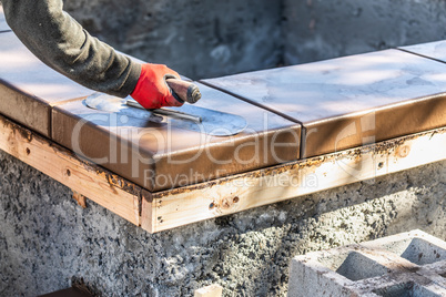 Construction Worker Using Trowel On Wet Cement Form Coping