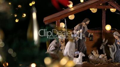 Jesus Christ Nativity scene with atmospheric lights near Christmas tree