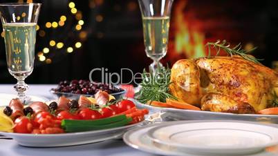 Roasted chicken on Christmas festive table near fireplace