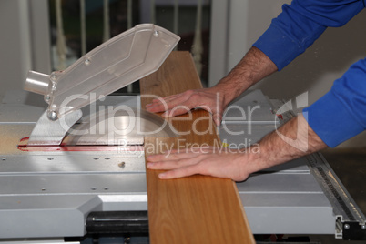 Worker laying parquet flooring. Worker installing wooden laminate flooring.