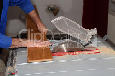 Worker laying parquet flooring. Worker installing wooden laminate flooring.