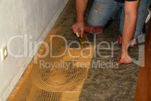 Worker laying parquet flooring. Worker installing wooden laminate flooring.