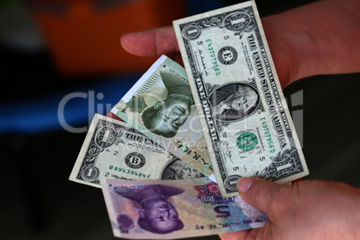Dollar vs Yuan. Dollars and yuan in the hands
