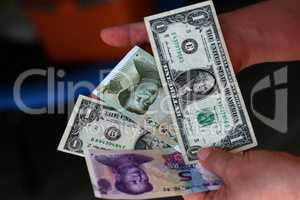 Dollar vs Yuan. Dollars and yuan in the hands