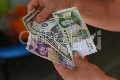 Dollar vs Yuan. Dollars and yuan in the hands